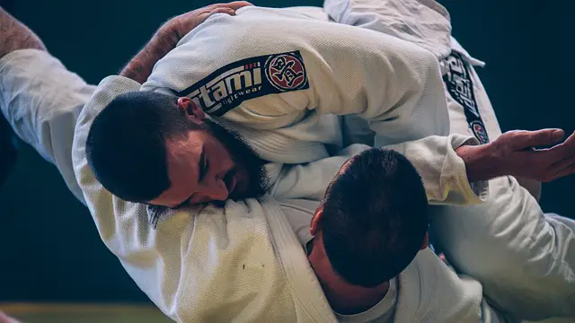 Two jiu jitsu beginners exchanging on the ground