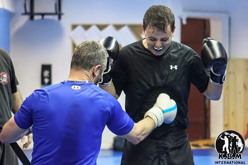 Boxing student practices how to absorb body shots