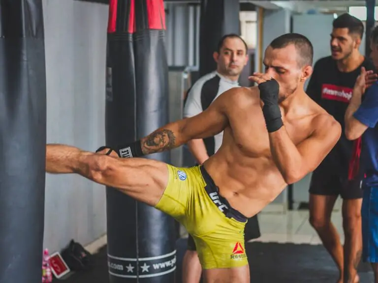 MMA practitioner landing a powerful kick on the heavy bag