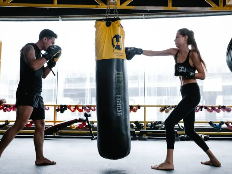 A man and a woman doing boxing drills on a heavy bag for weight loss