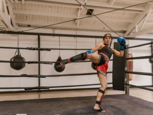 Woman Muay Thai practitioner throwing a roundhouse kick