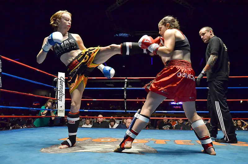 Muay Thai women fighter landing a front kick