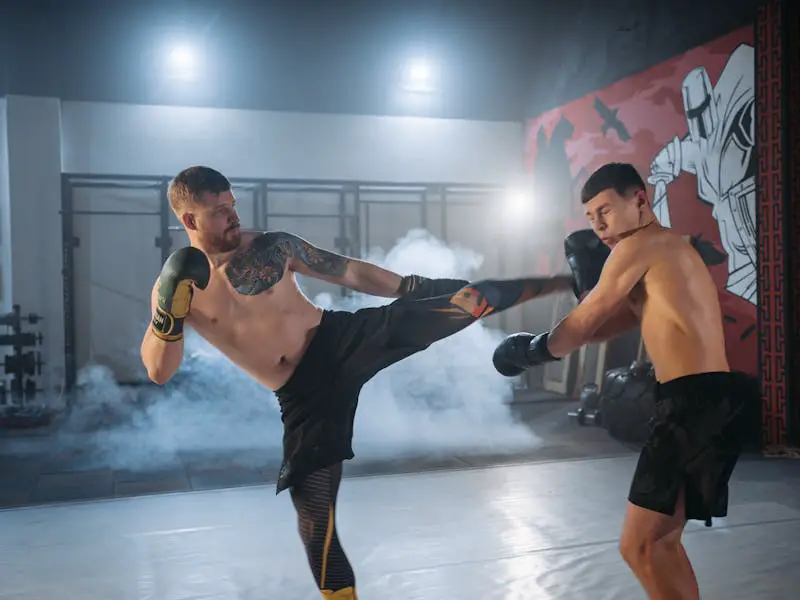 two MMA students practicing Muay Thai kicks