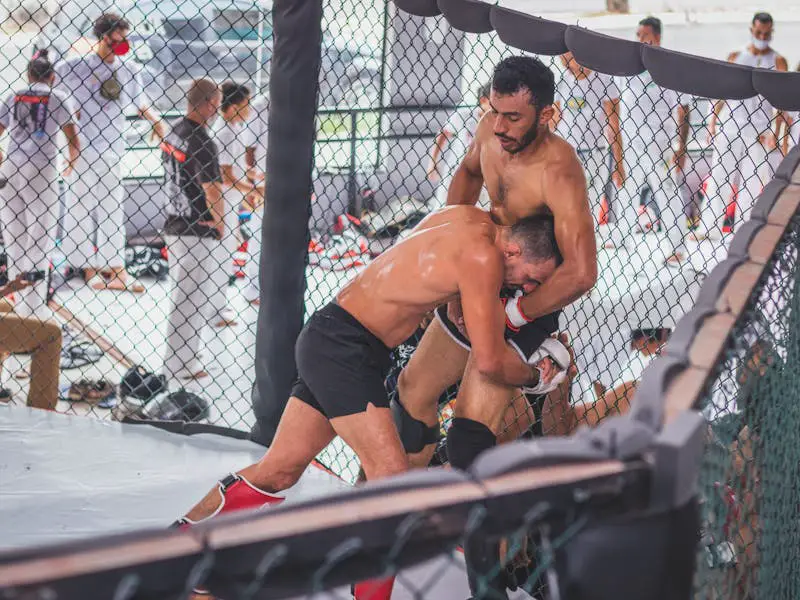 MMA fighter defending a takedown against the fence