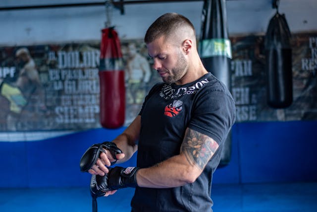 Practitioner putting on MMA sparring gloves